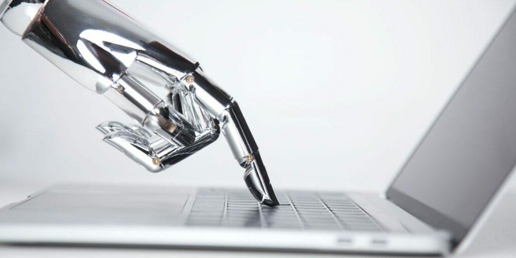 Blog banner showing a robotic hand pressing a laptop keyboard to illustrate the title "Machine Translation vs. human Translation: Will Artificial Intelligence Replace the World’s Second Oldest Profession?"